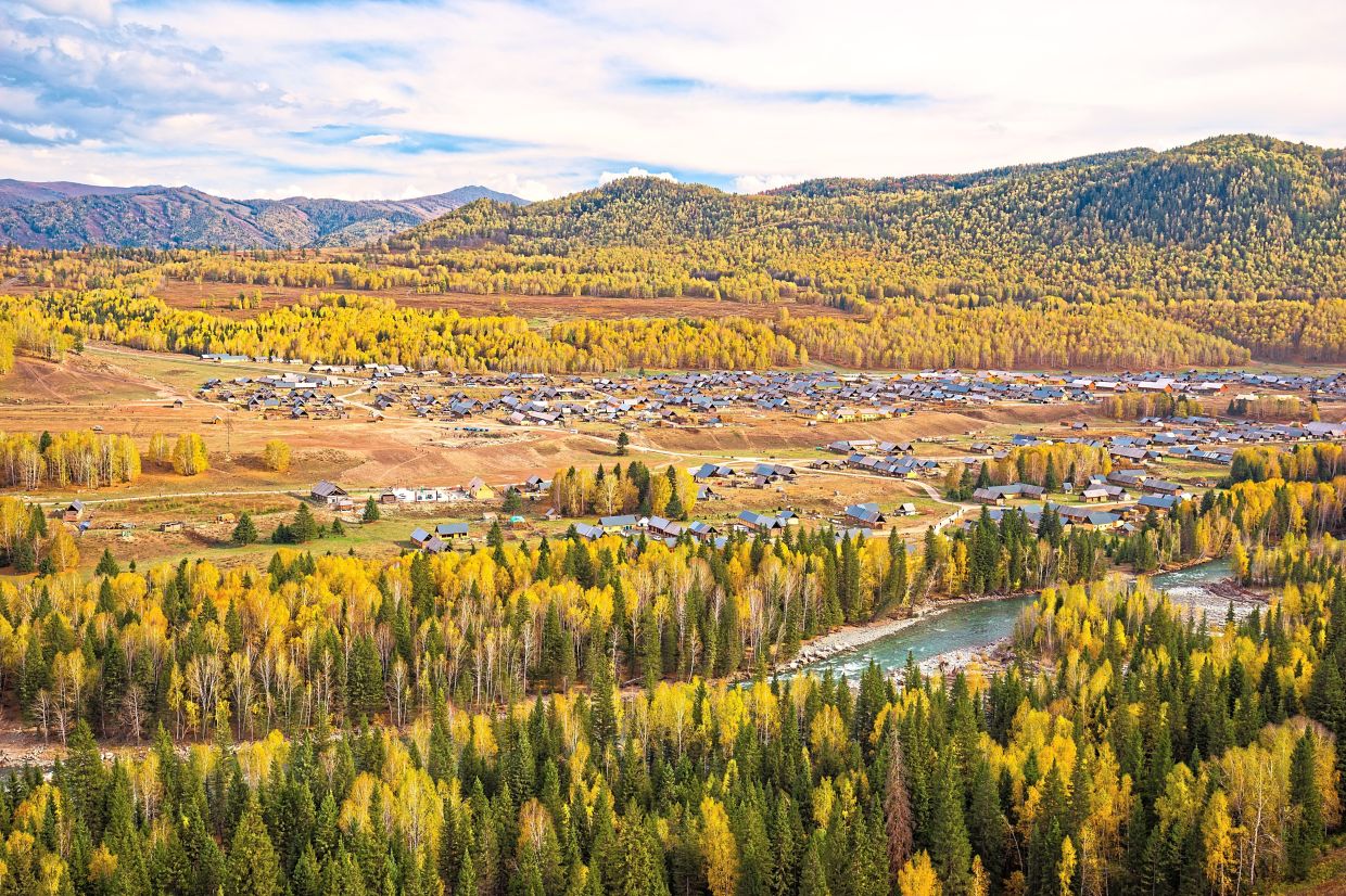 The picturesque Hemu Village in Xinjiang, surrounded by golden birch forests, is one of the many breathtaking landscapes accessible through the Urumqi charter flight series.