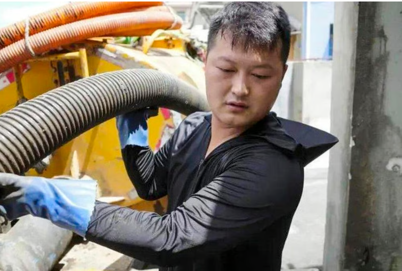 Pan Haonan hard at work on what he described as a “dirty and smelly” job.www.worldjournal.com