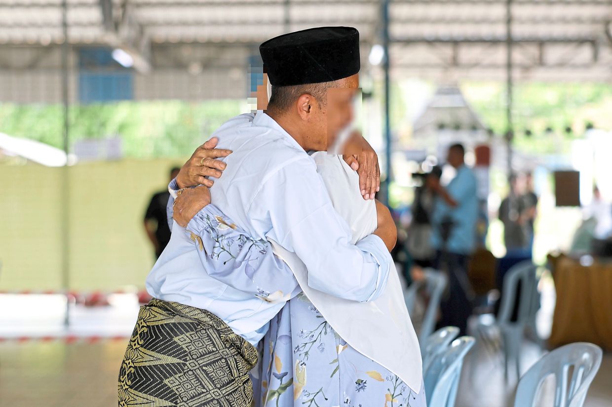 A PRP resident hugging his wife during the Aidilfitri event.