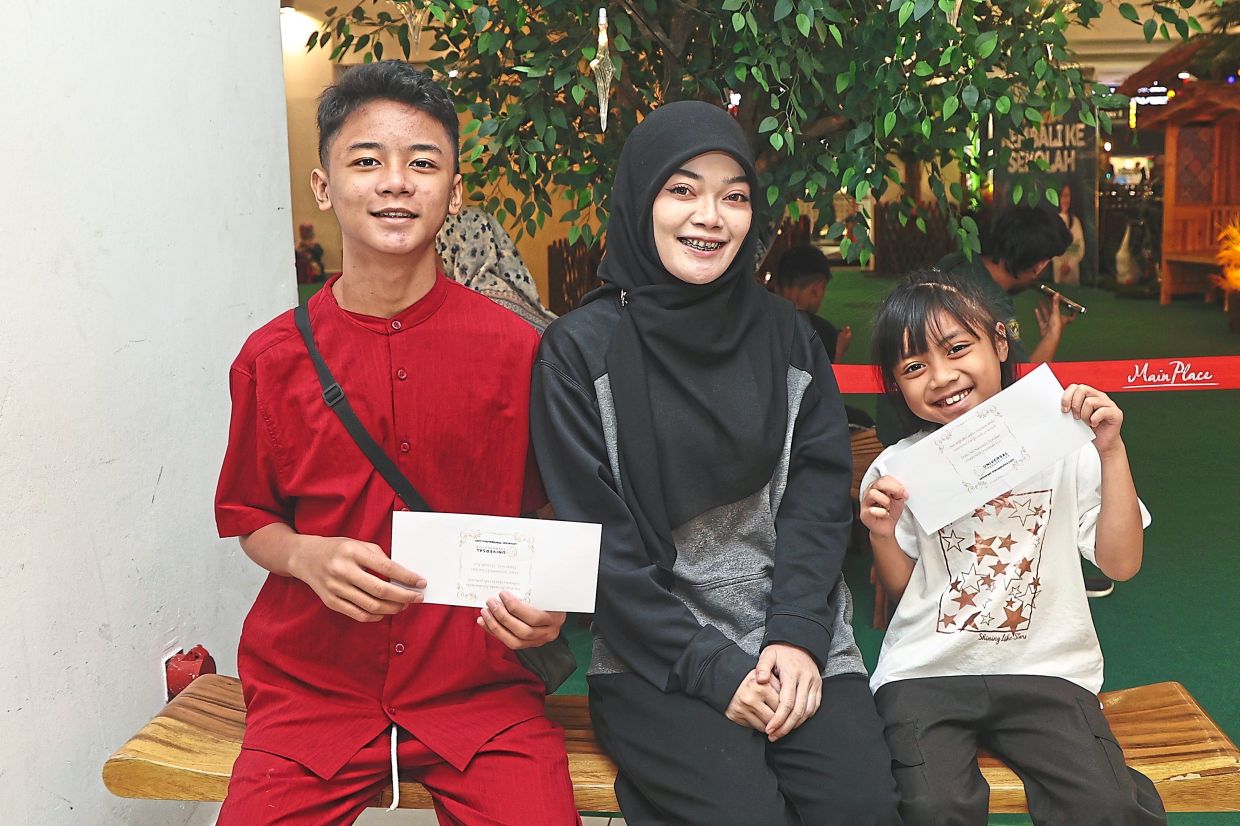 Hernah Suziyanti with her children Aurellia Elldora and Putra Farrel after the back-to-school aid presentation.
