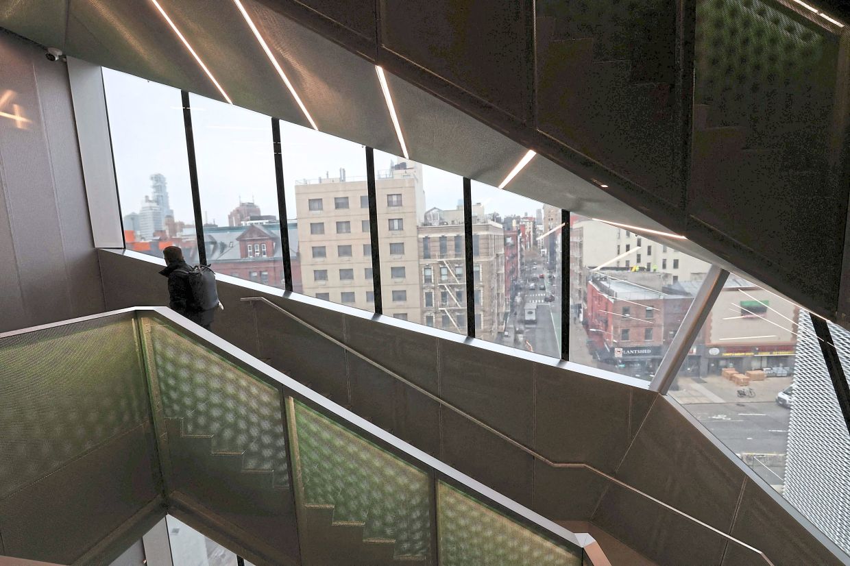 The new building takes the form of a multifaceted prism, with deep diagonal setbacks to balance the horizontal volumes of the first building. Triangular apertures open up terrace views on the upper floors. Photo: AFP