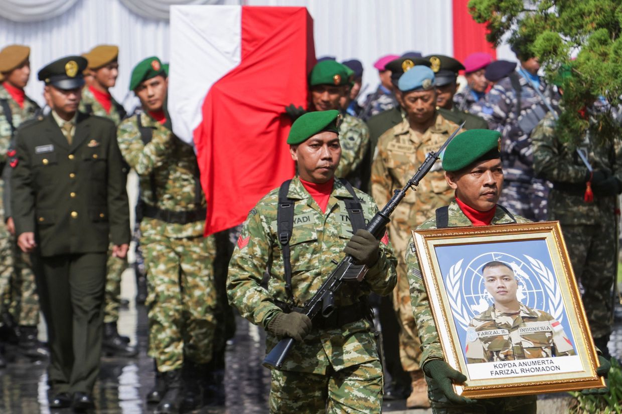 Indonesian military personnel carrying a photograph and the coffin of late Farizal Rhomadhon, a United Nations Interim Force in Lebanon peacekeeper killed in Lebanon, during the funeral ceremony at Giripeni Heroes Cemetery complex in Kulon Progo regency, Yogyakarta on April 5, 2026. - Reuters