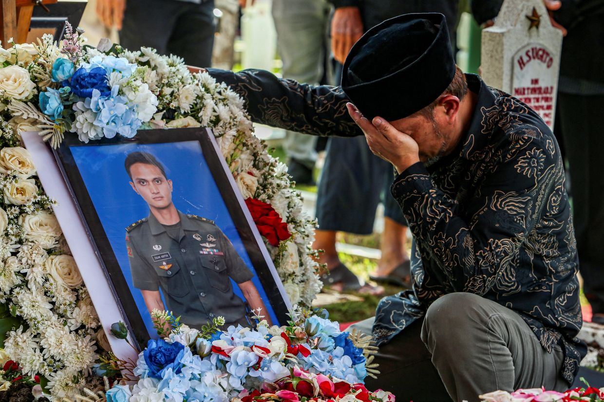 A relative mourning next to the grave of Zulmi Aditya Iskandar, one of the peacekeepers in United Nations Interim Force in Lebanon killed in Lebanon, after the funeral ceremony in Bandung on April 5, 2026. - Reuters