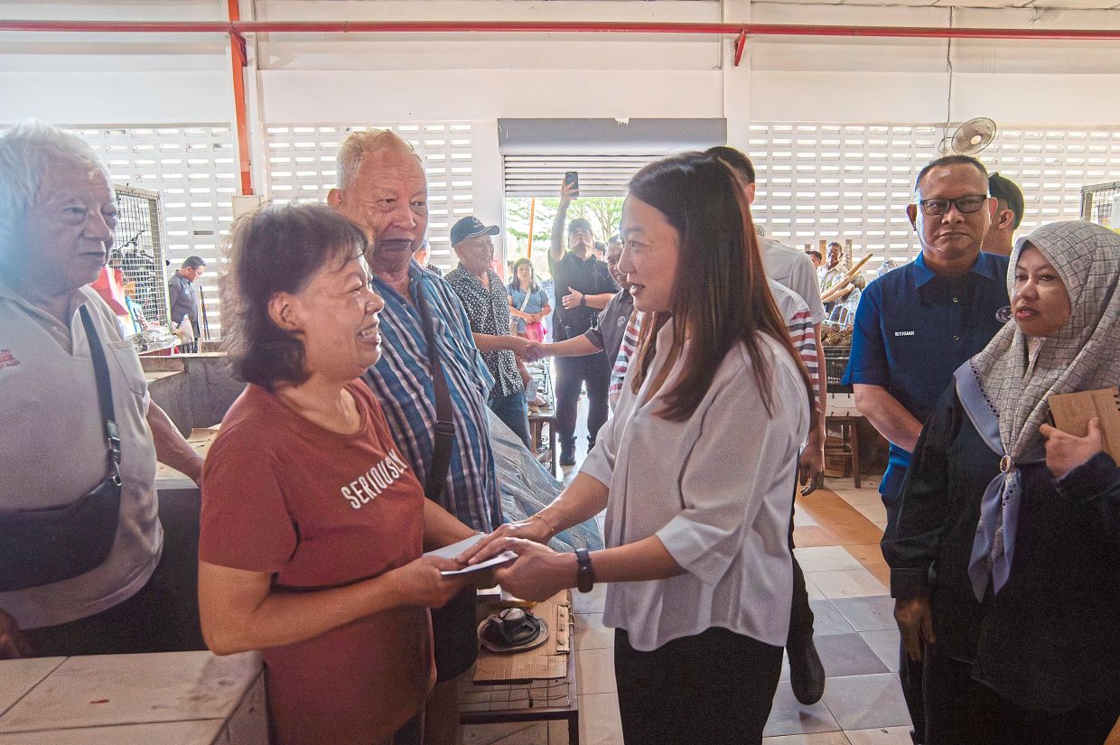 Yeoh (third from right) passing a government contribution to a victim of the Pasar Sentral fire on March 13.