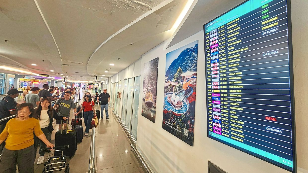 The busy arrival hall at Penang International Airport. — FilepicLeft: Wong (centre) taking a group photo with participants at the Qingdao Airlines networking session. — ZHAFARAN NASIB/The Star
