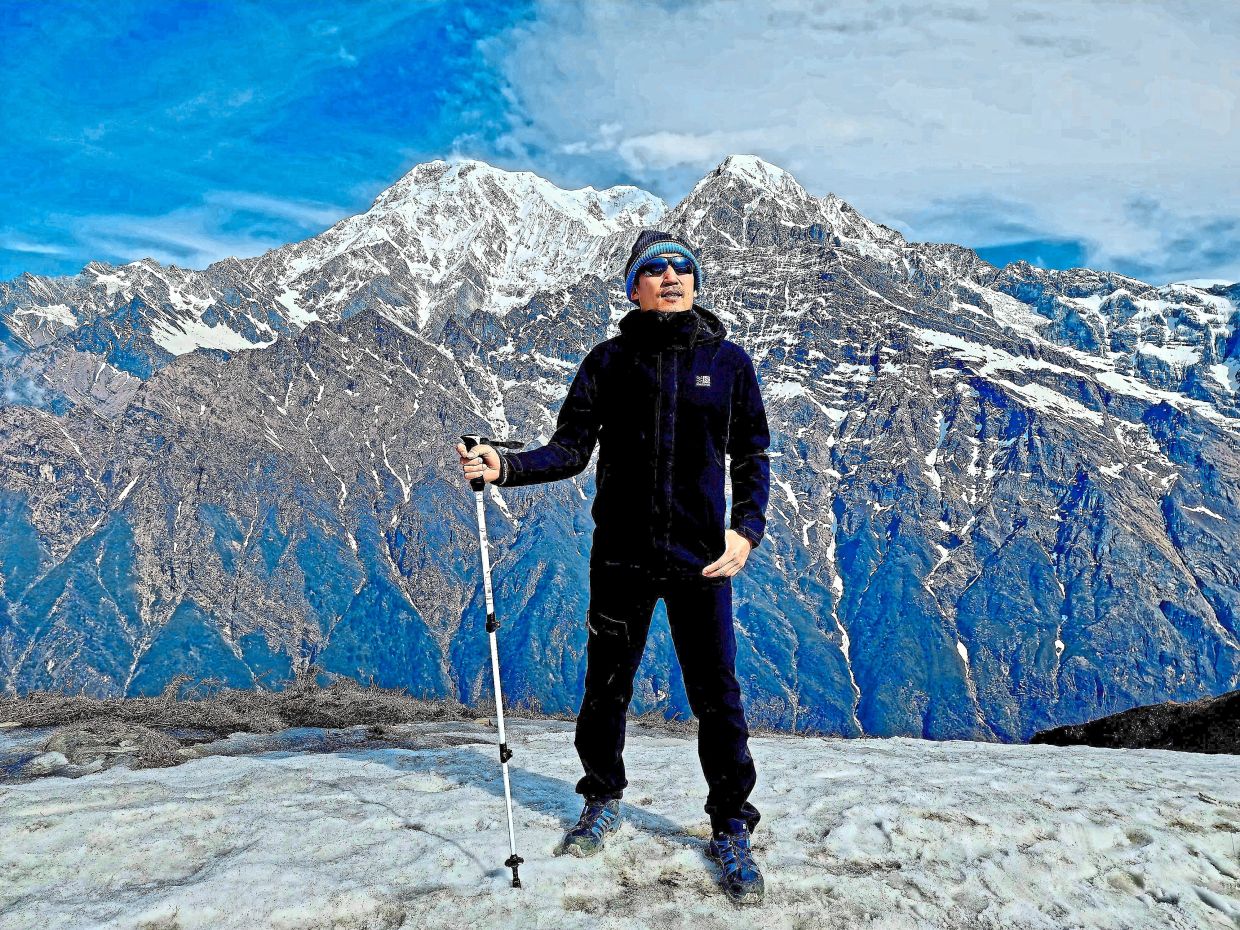 Doing the impossible: Yuen posing for a photograph at the Mardi Himal Viewpoint in the Himalayas, Nepal.