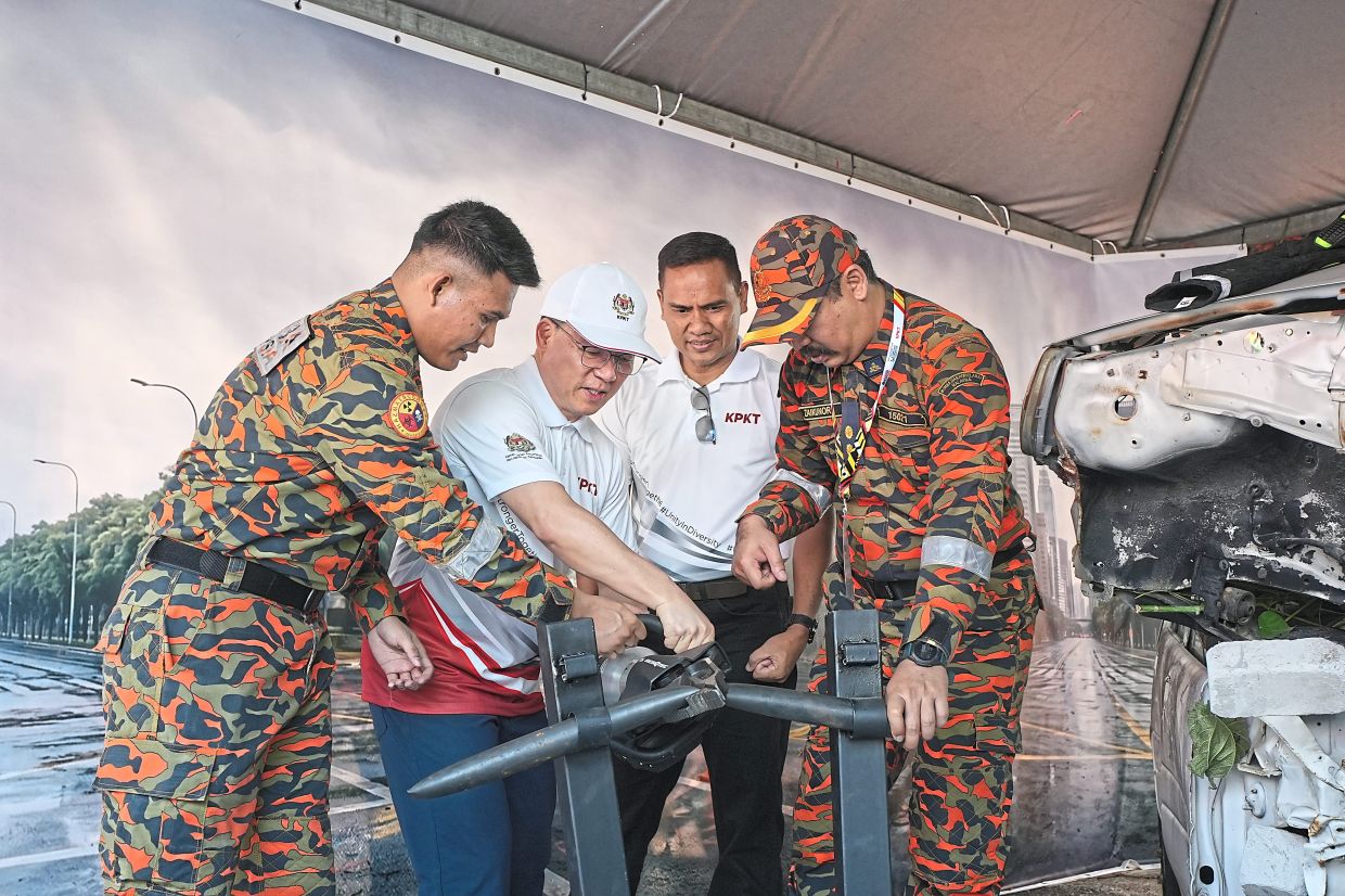 Nga (in cap) checking out Fire and Rescue Department equipment as KPKT secretary-general Datuk Dr M. Noor Azman Taib (second from right) looks on. 