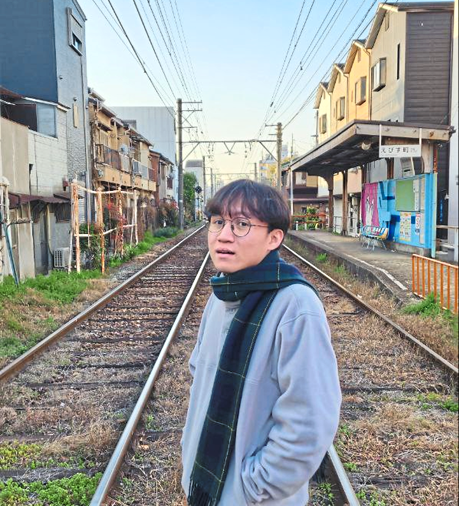 The writer at a train crossing in Nishinari, Osaka.