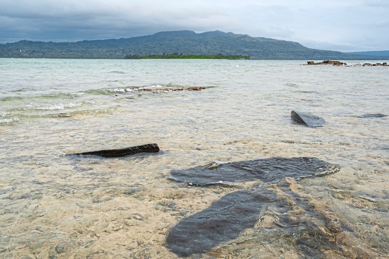Gravestones sit submerged in water on Pele Island, Vanuatu, a country heavily affected by rising seas. — AP
