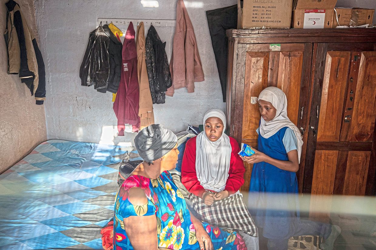 Alima Nasur talks to her daughters, Salama Halima (centre) and Buthaina Halima (right) about menstrual health. Photo: AP