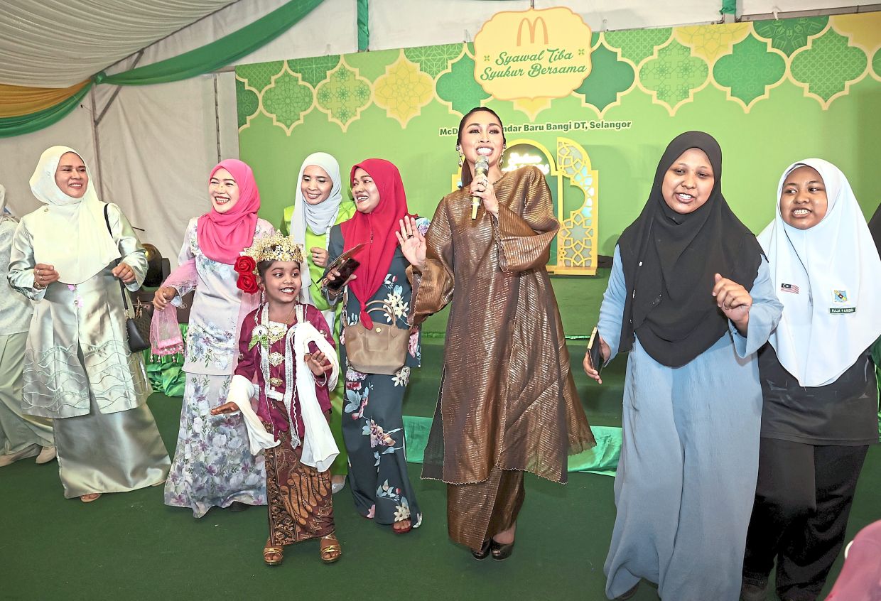 Dayang Nurfaizah (third from right) entertaining the crowd at the McDonald’s Hari Raya event. 