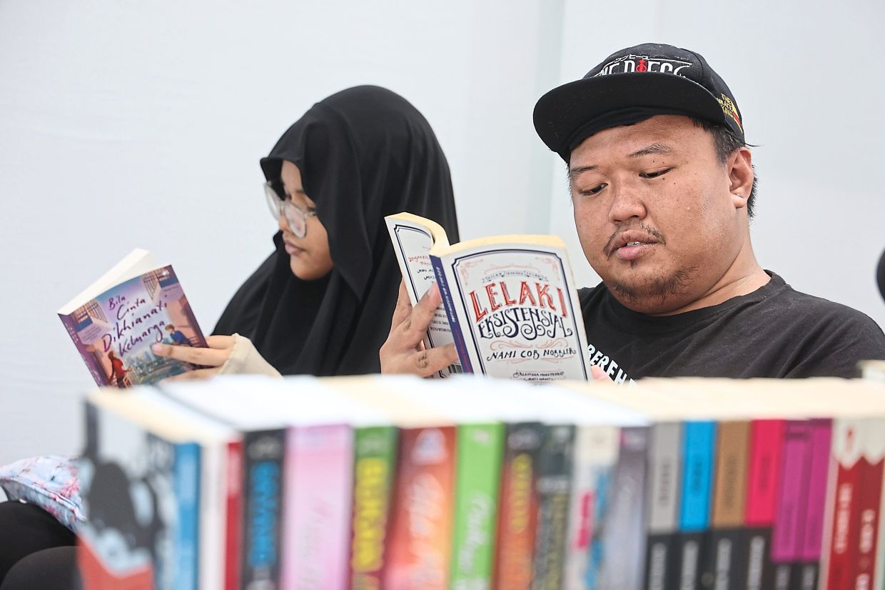 Vendors squeezing in some reading at their stalls while waiting for customers during the fair.