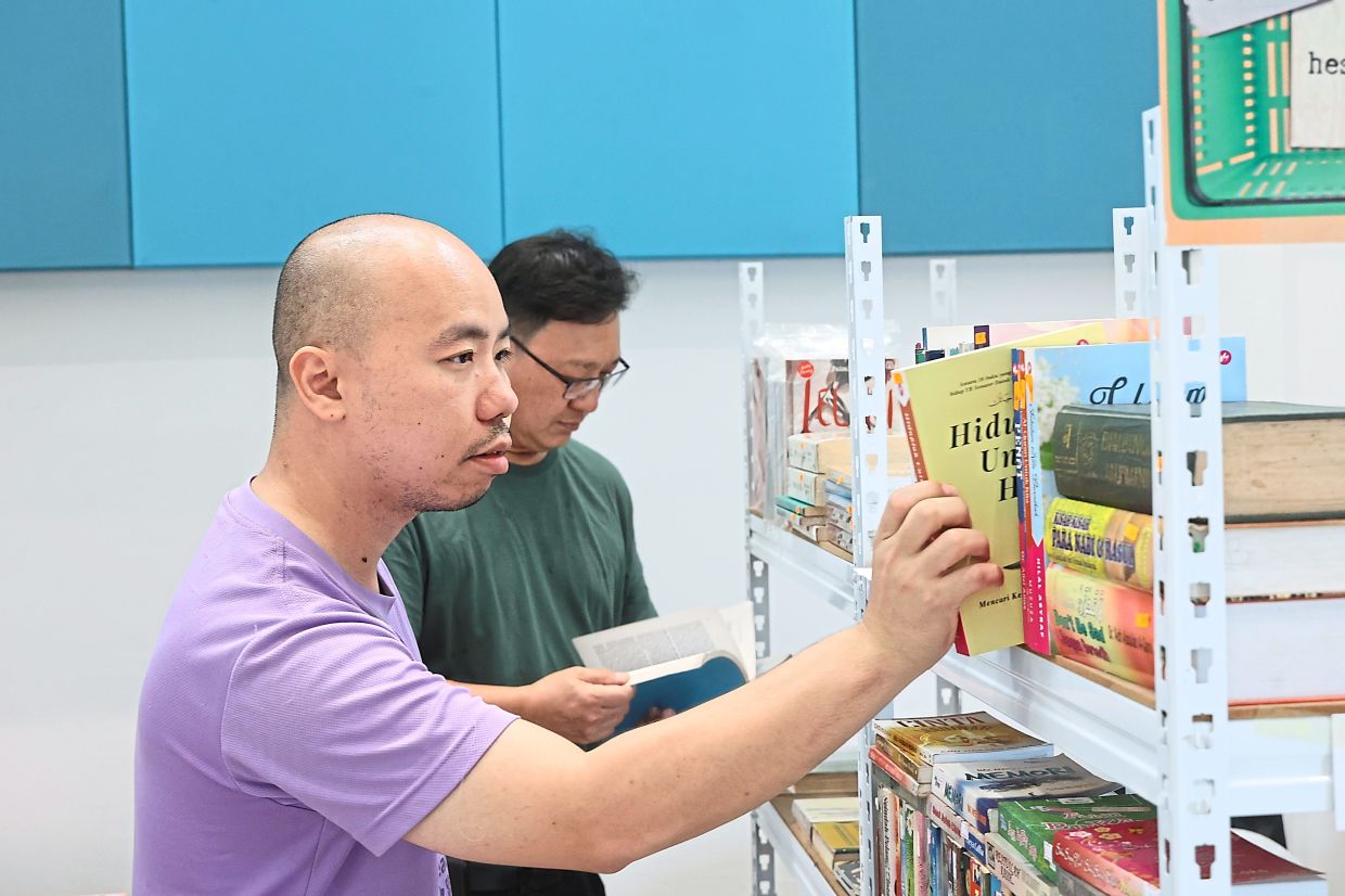 Gan (left) and his friend Tan Chin Heap browsing through preloved books at ‘Paso Buku’.