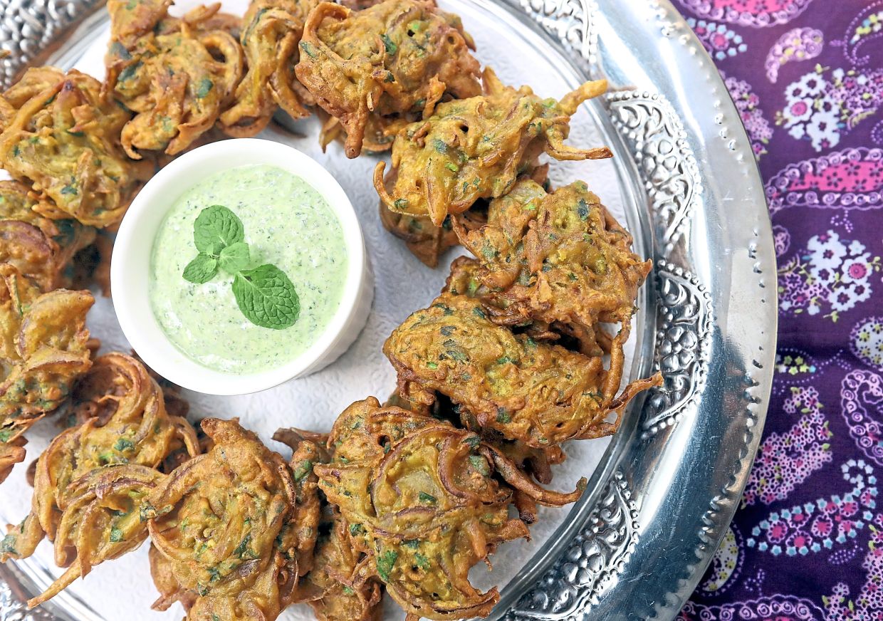 Fried until golden and crispy and served with a mint yoghurt dip, these onion pakoras are the perfect starter for a family gathering. Right: Fresh herbs and spices make up ingredients for a vegetarian option. — Photos: AZLINA ABDULLAH/The Star
