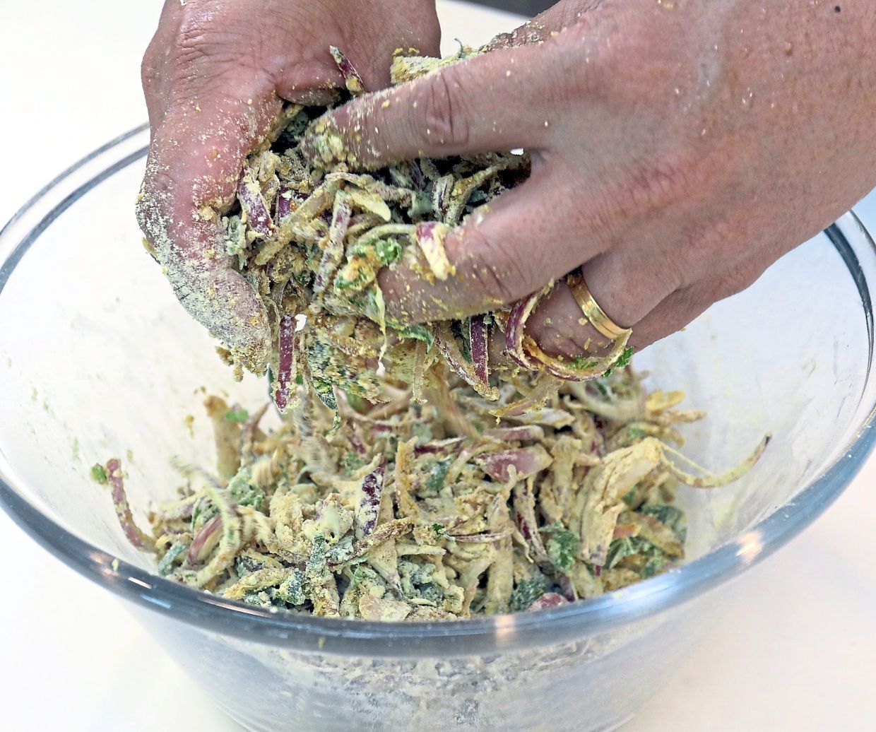 Toss in chickpea flour and rice flour until evenly distributed, then gradually pour in cold water to mix into a thick and sticky batter.— AZLINA ABDULLAH/The Star