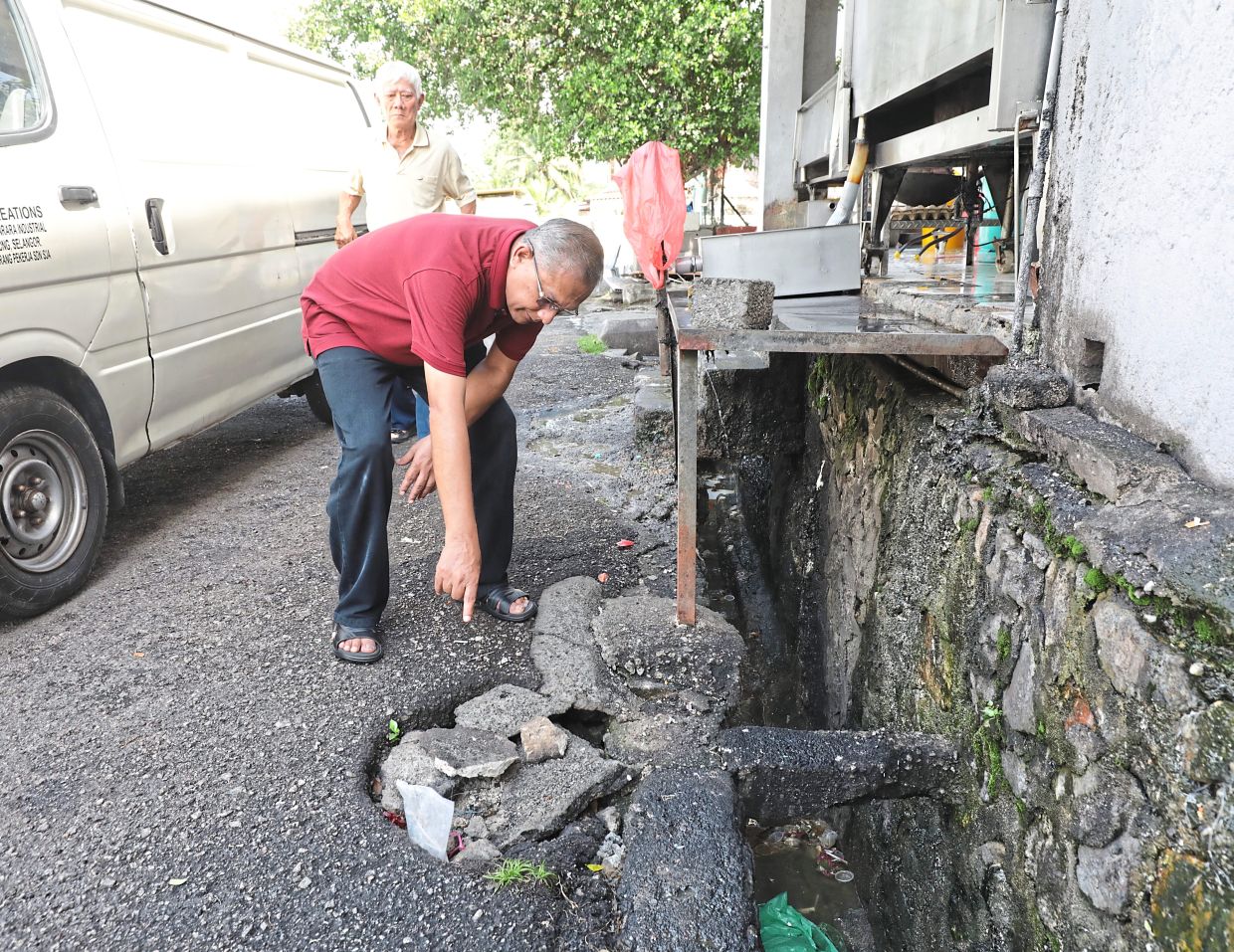 Vincent showing the bad state of drains at Taman Bukit Belimbing in Balakong. — Photos: SAMUEL ONG/The Star