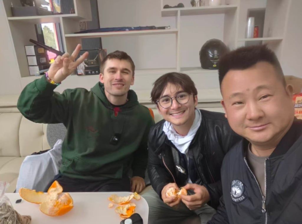 The two visitors enjoy some oranges with one of their Chinese hosts. - Photo: Baidu