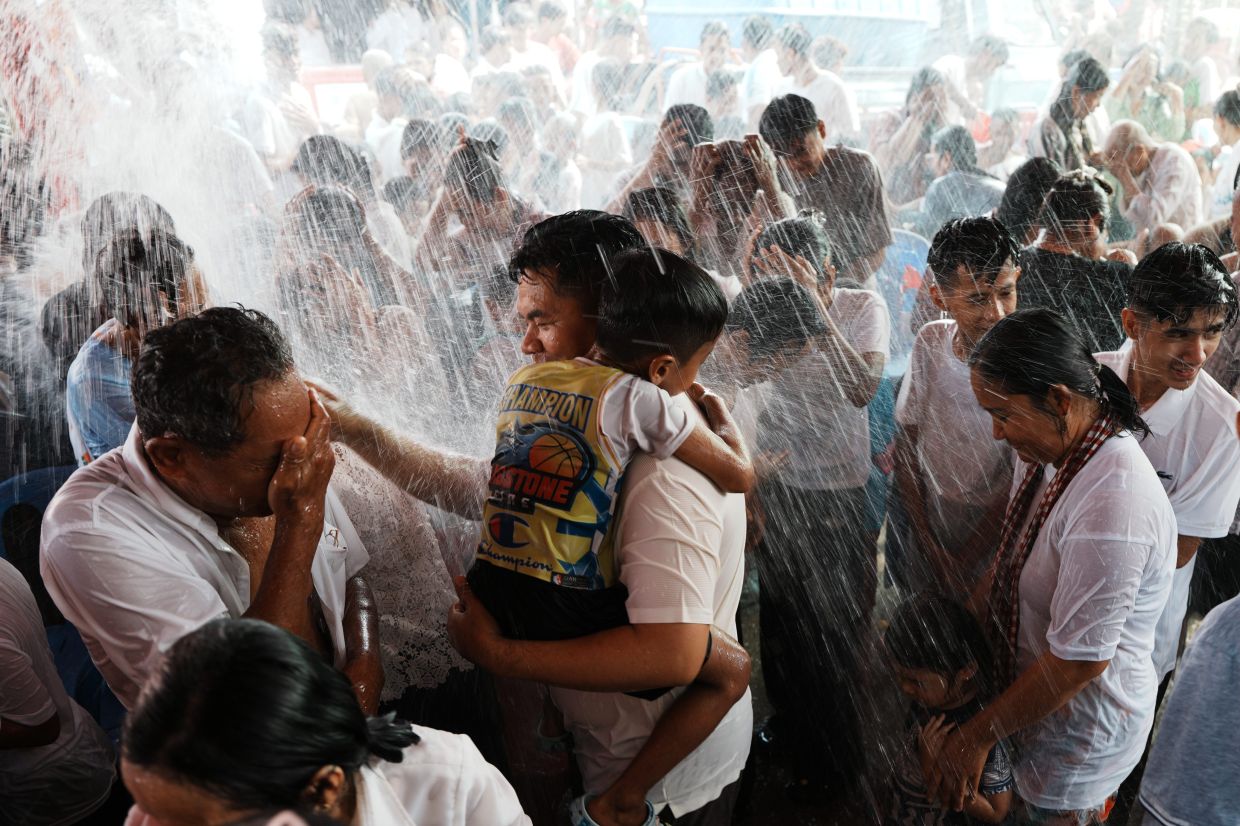 Residents of Prey Popel village receive a holy water shower, which is believed to bring good luck, during Khmer New Year celebrations on the outskirts of Phnom Penh, Cambodia, on Sunday, April 12, 2026. -- AP Photo/Heng Sinith