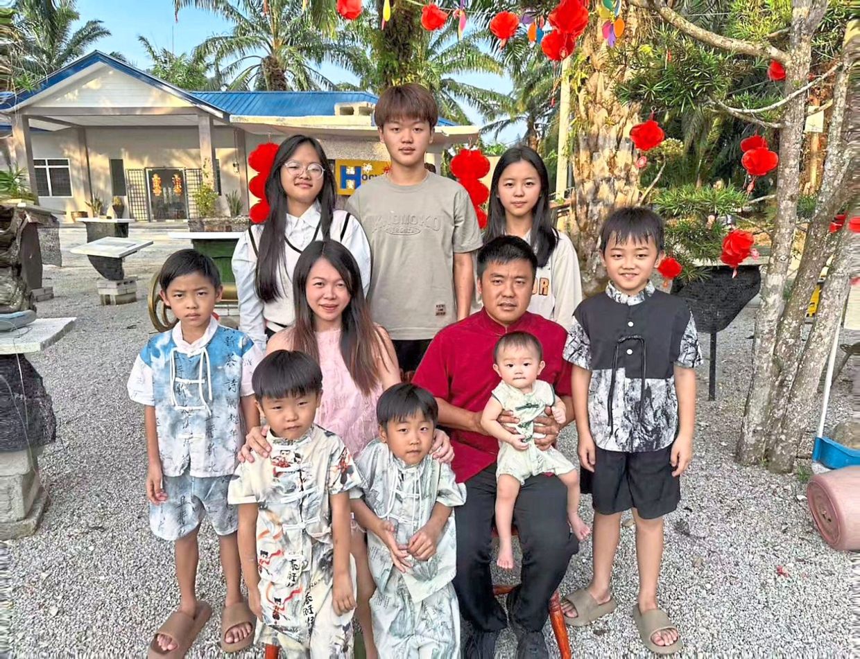 Soh (in red), with his wife Gwee Pei Leng (on his right) and their children, says he feels anxious about the future.