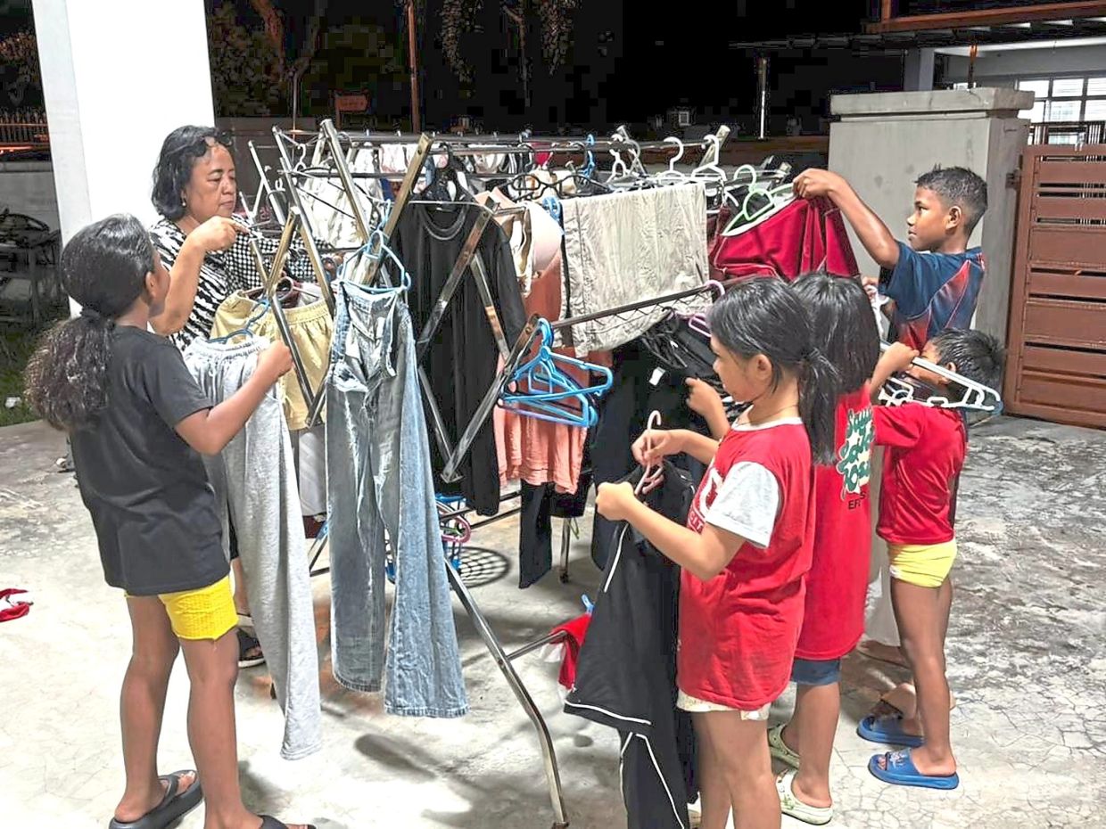 Marry (second from left) teaches her foster children about reducing electricity usage.