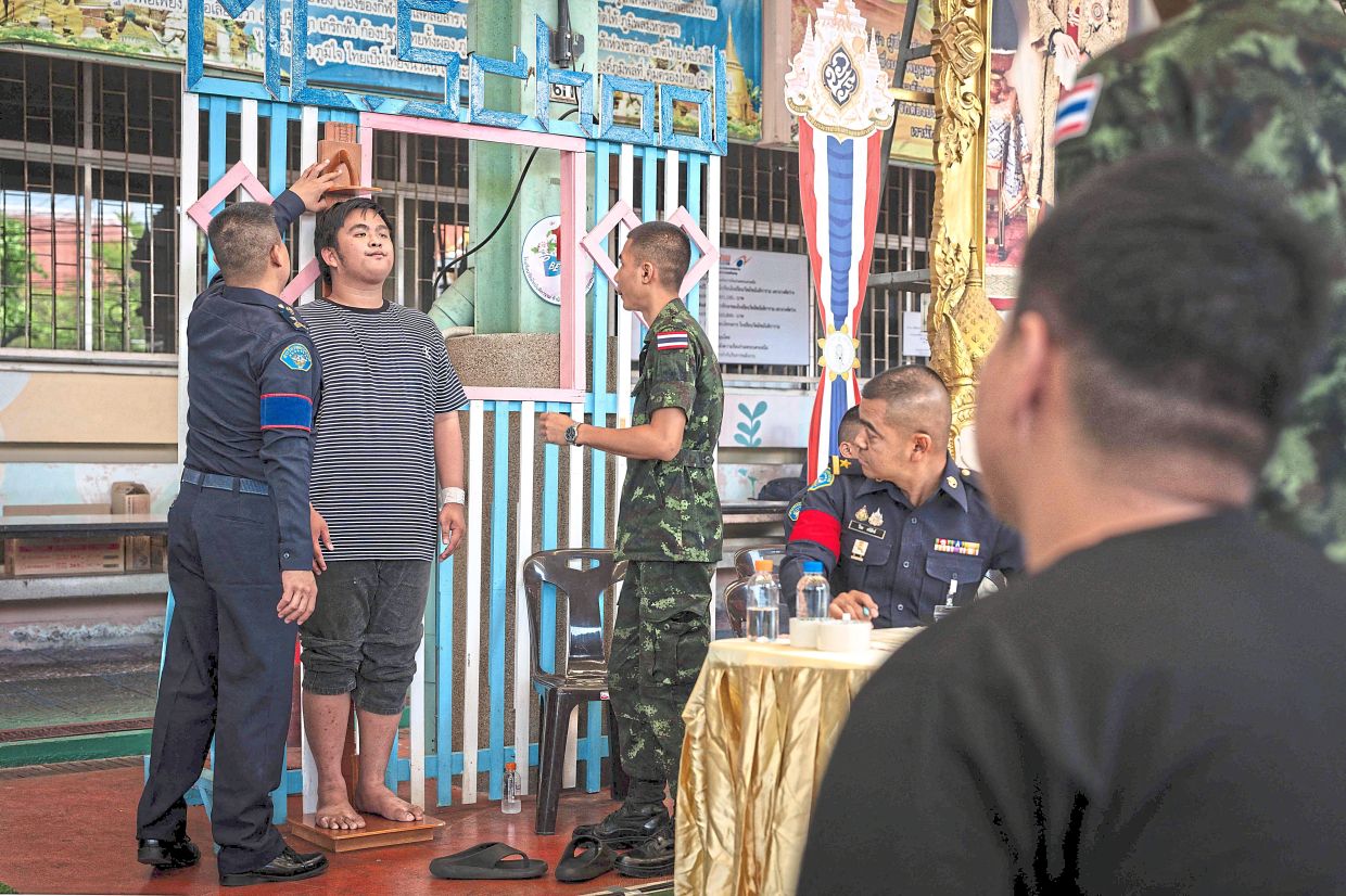 Hitting the mark: A man has his height measured before drawing a ballot. — AFP