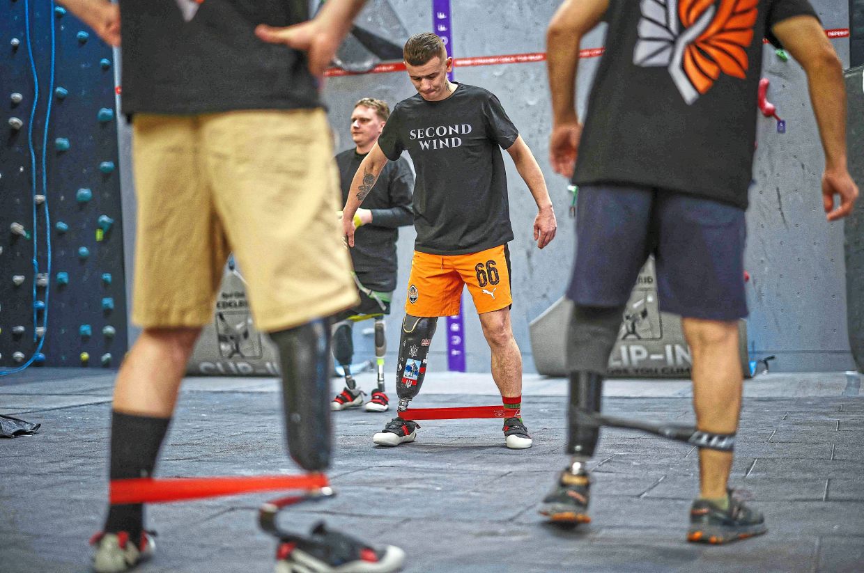 Former Ukrainian service personnel warm up together.