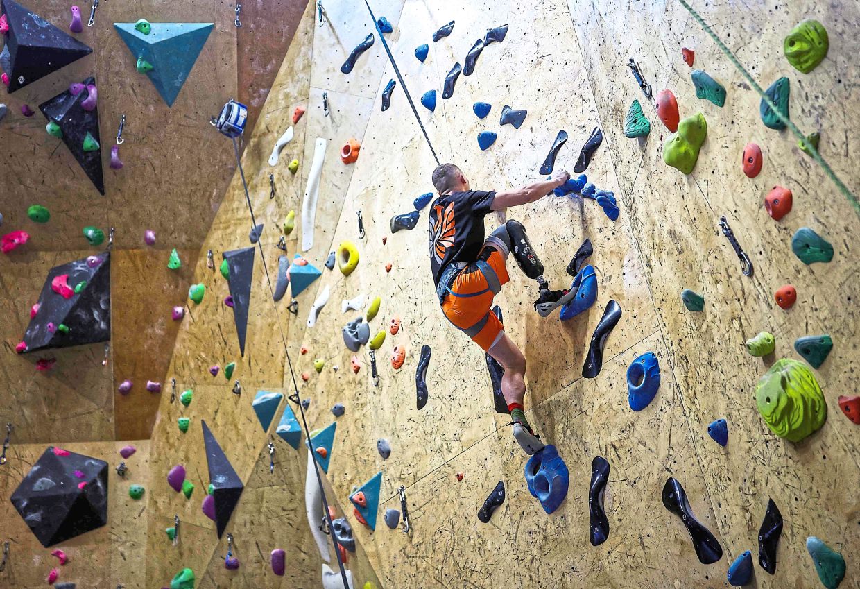 Former Ukrainian service member Dmytro Mekhasiuk takes part in an indoor climbing session.