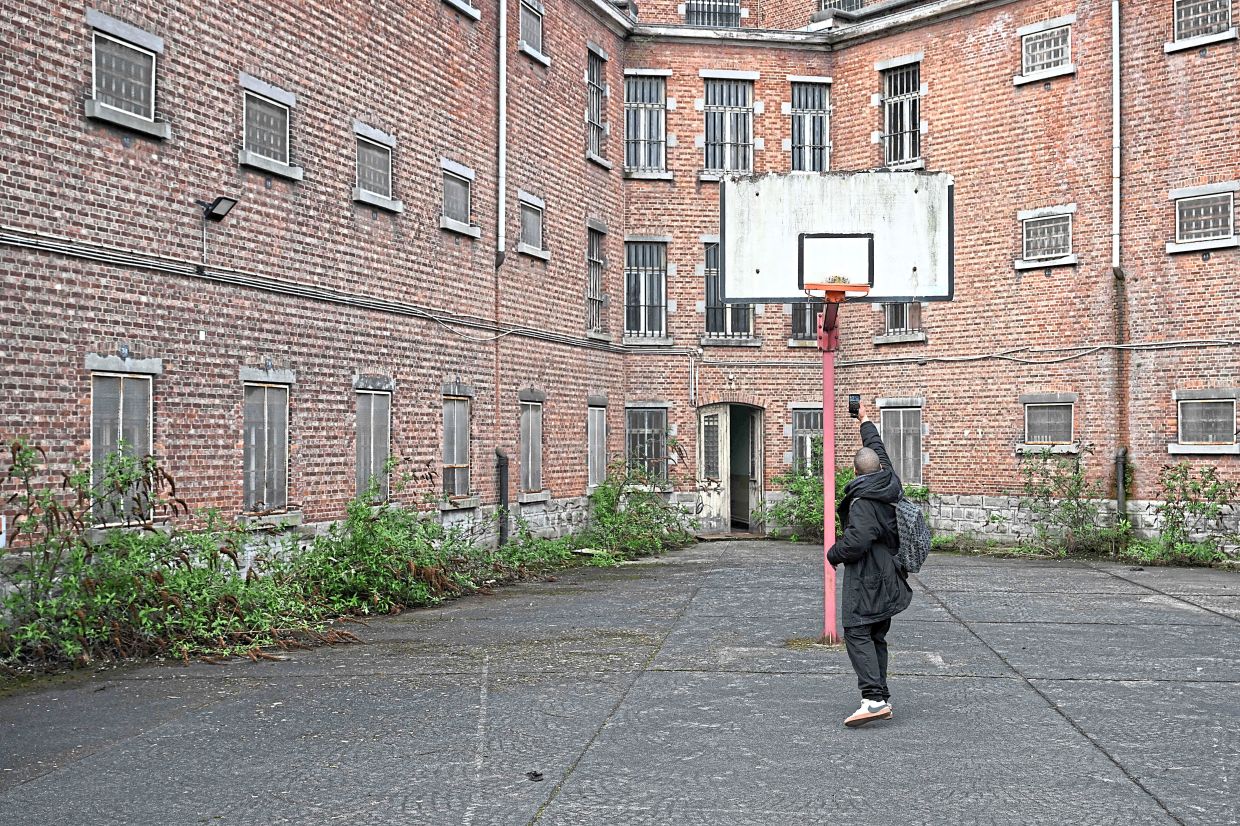 A visitor taking pictures of a basketball rim in the prison yard.