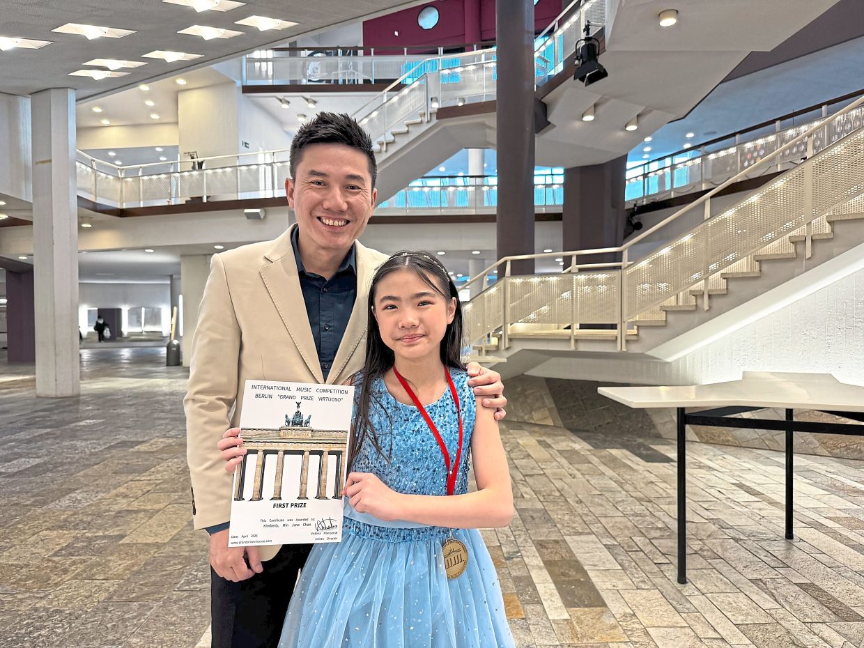 Chan (left) stands proudly beside Kimberly in Berlin after she won the first prize in the International Music Competition Berlin (Grand Prize Virtuoso) in February.