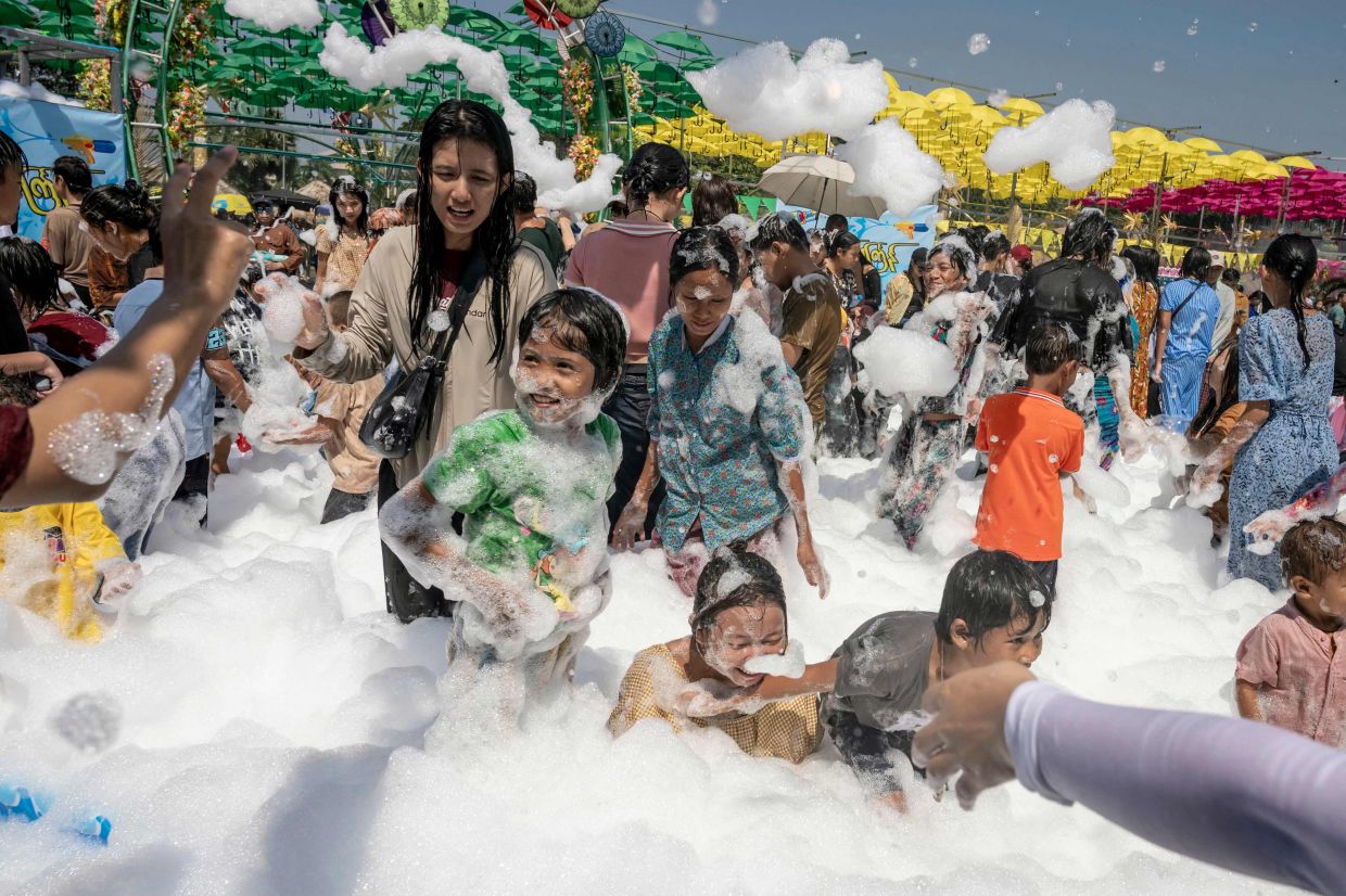 People play with soap suds during celebrations for Myanmar's Buddhist New Year water festival, also known as Thingyan, in Yangon on Monday, April 13, 2026. -- Photo by Sai Aung MAIN / AFP