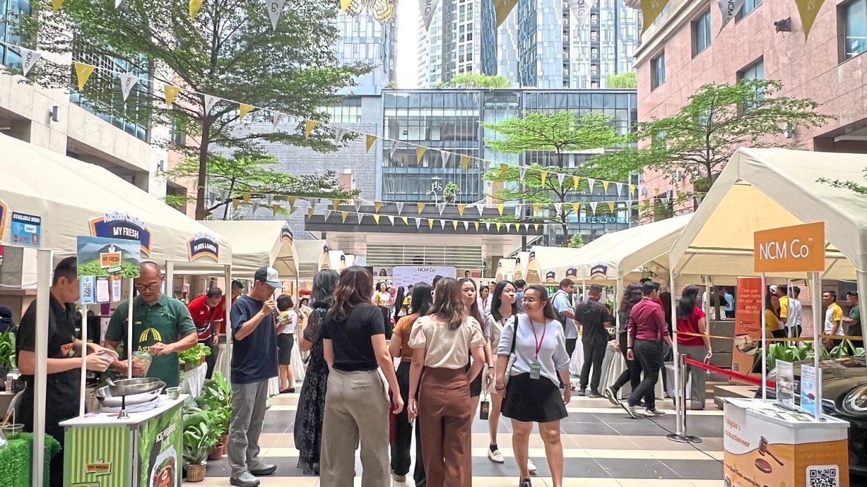 Visitors exploring booths at an NCM Co Auction Carnival in Kuala Lumpur.