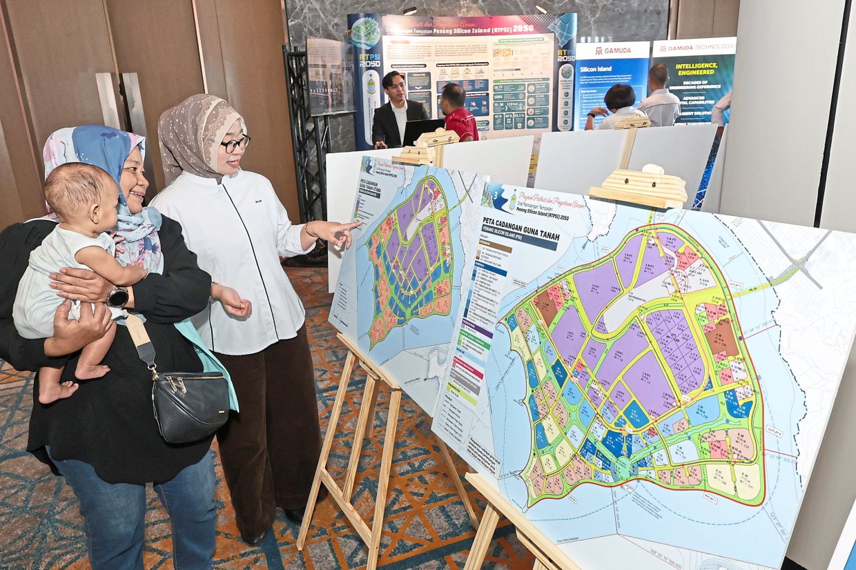 Penang Infrastructure Corporation staff Alia Mohd Norhisham (right) explaining the proposed plan for Silicon Island to Fauziah Hani Yacob, 62, during a public publicity programme. — Filepic