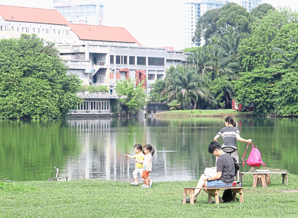 Visitors can be seen walking or gathering around the lake and on the green grass.