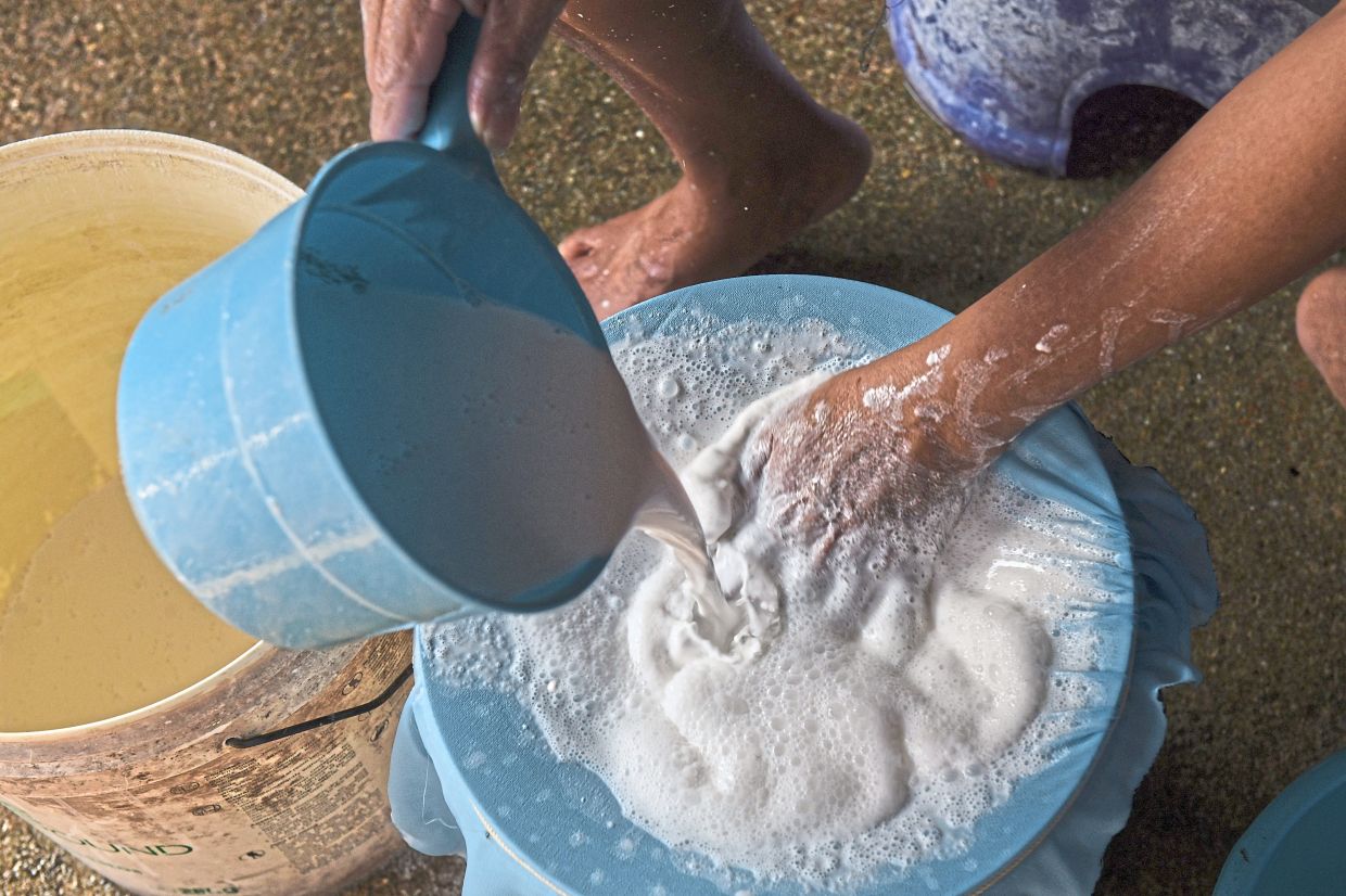 Yeoh straining the bedak sejuk mixture in a lengthy production process. — Bernama