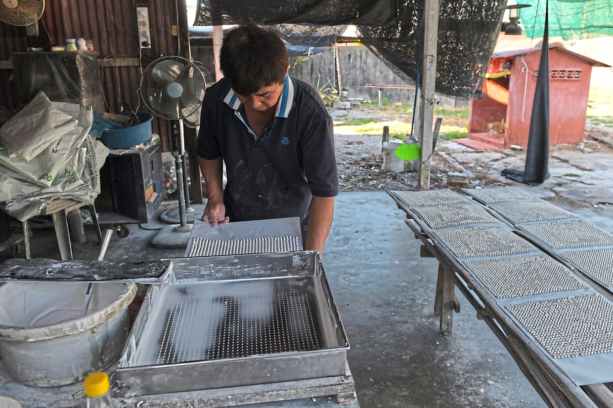 The process of making the cooling powder is lengthy and includes sifting of the fermented rice mixture (above) and turning the resulting paste into pellets (below).
