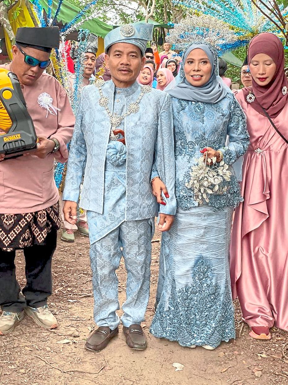 Haniin and Rahmat making their way to the top of Bukit 527 for their wedding reception with friends and fellow hikers. — Bernama