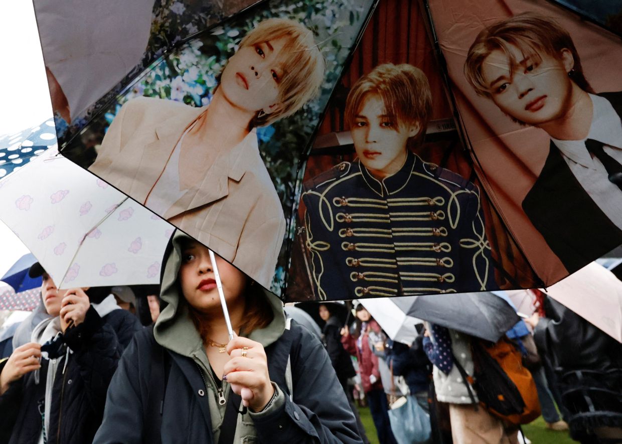 A BTS fan carrying an umbrella with Jimin's images waiting in line to enter the concert venue, Goyang stadium, in Goyang, South Korea on April 9. -- Reuters 