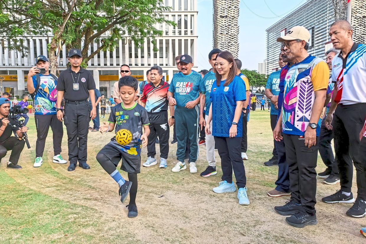 Yeoh watching a youngster doing kick-ups.