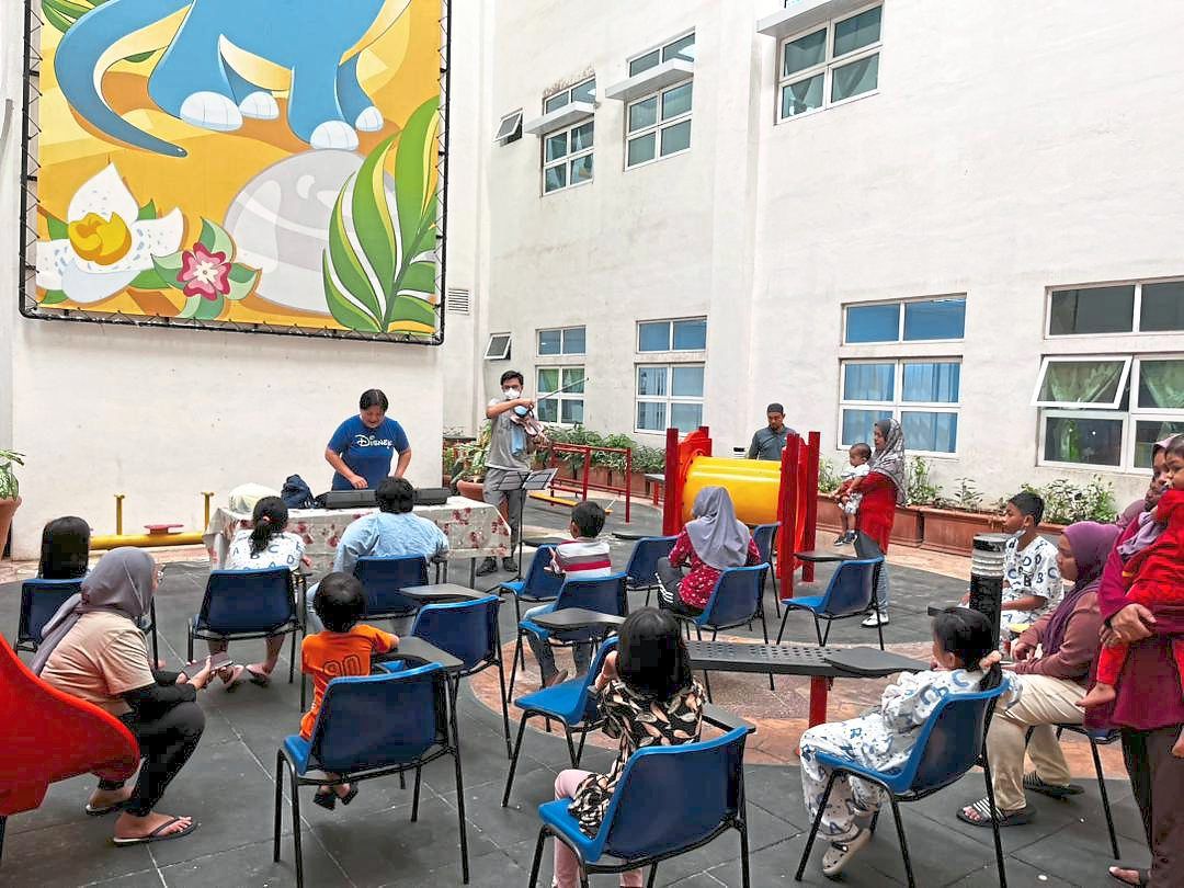 Wong (in blue) connects with young paediatric palliative care patients through music therapy at Hospital Tuanku Jaafar in Seremban. Photo: Dr Noor Suraya Muhamad 