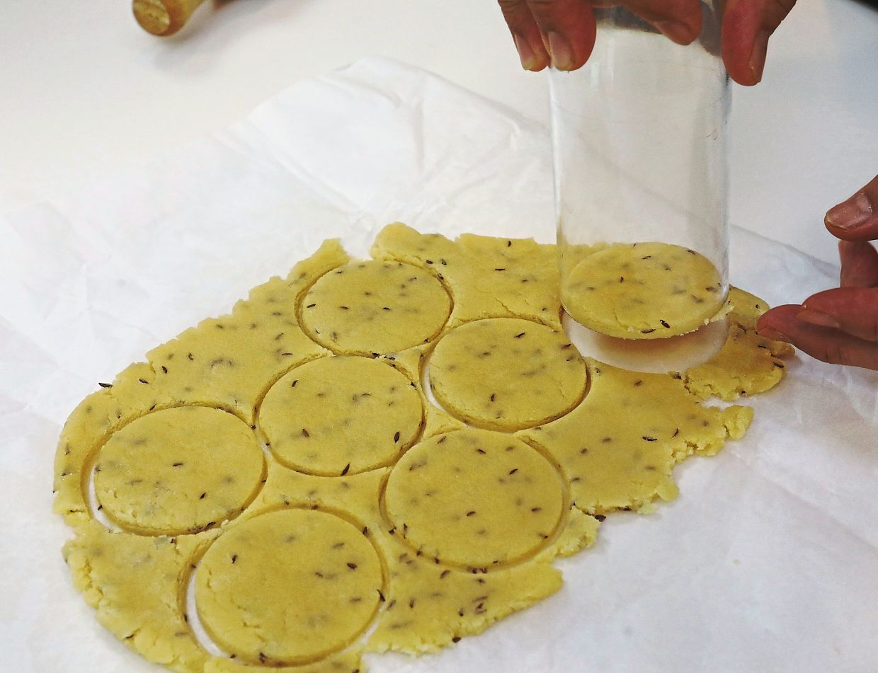 Break up portions of the dough and roll it into a thin sheet of about ¼cm thick and cut with the rim of a 6cm glass tumbler or round cookie cutter.