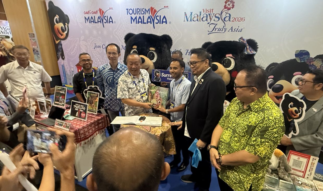 Jafry receiving a book on Malaysia’s flora and fauna from Tourism Malaysia official.