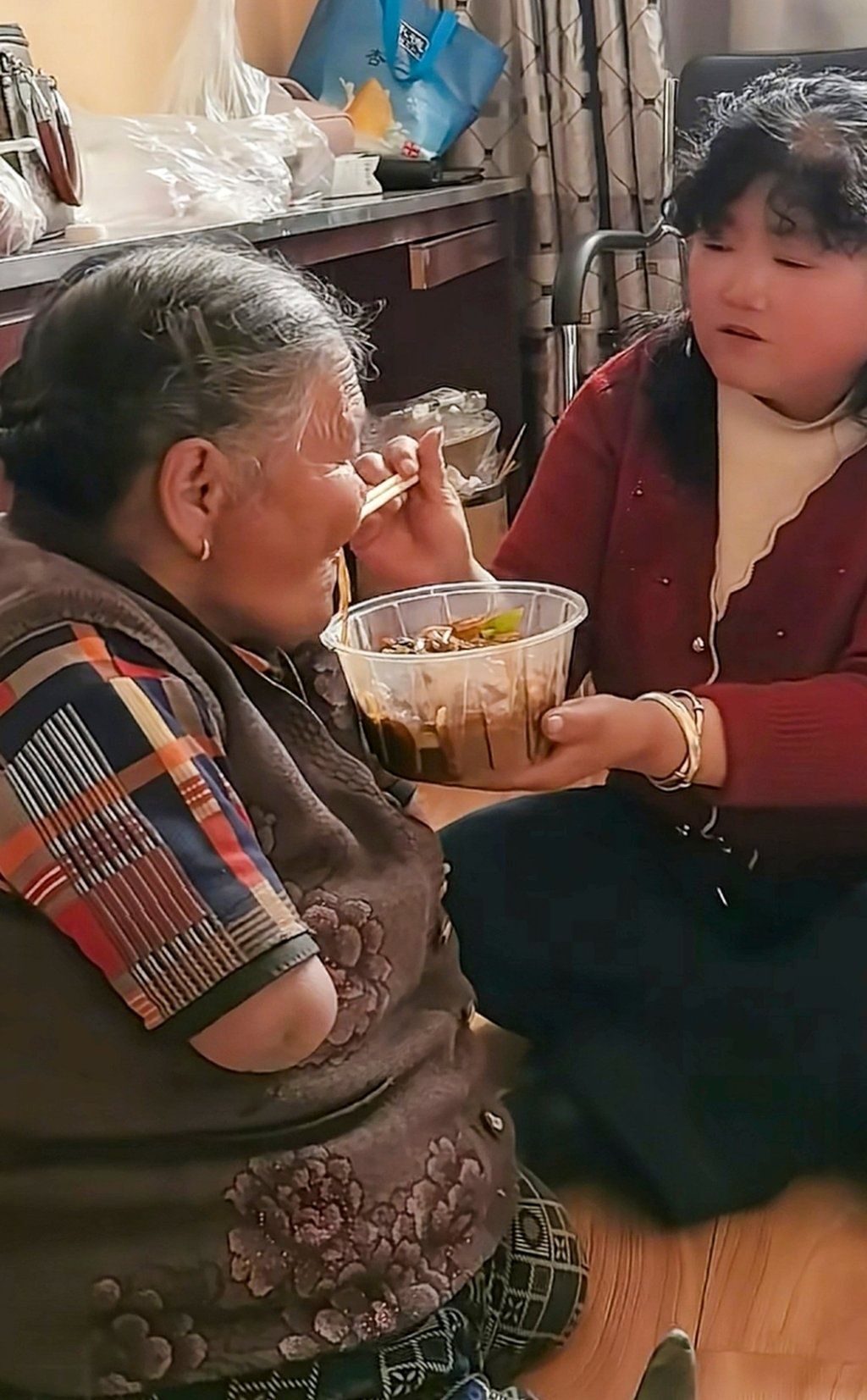 Wang’s dutiful daughter helps her mother tuck into some food. - Photo: baijiahao.baidu.com