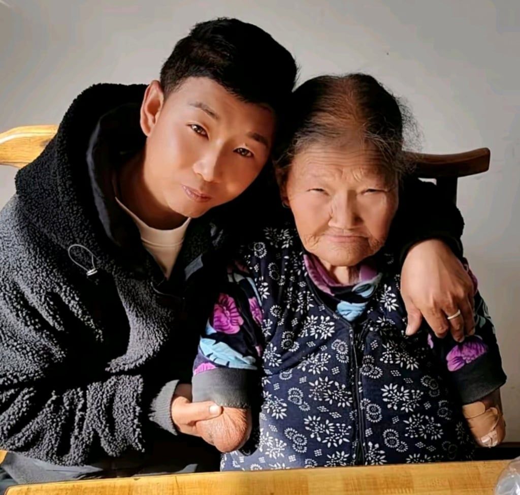 A smiling Wang poses for a photograph with one of her sons. - Photo: baijiahao.baidu.com