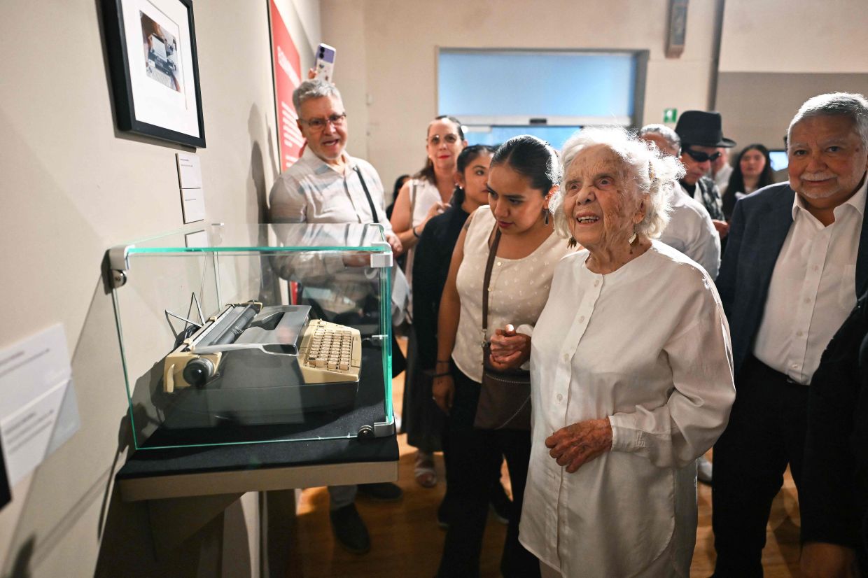 Poniatowska stands next to her typewriter during the opening of the exhibition in Mexico City. Photo: AFP