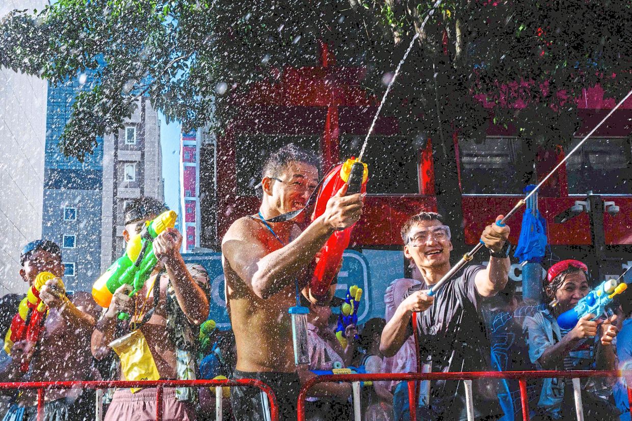 Water guns blast through the air as revellers take part in a high-energy Songkran water fight in Bangkok. — AFP
