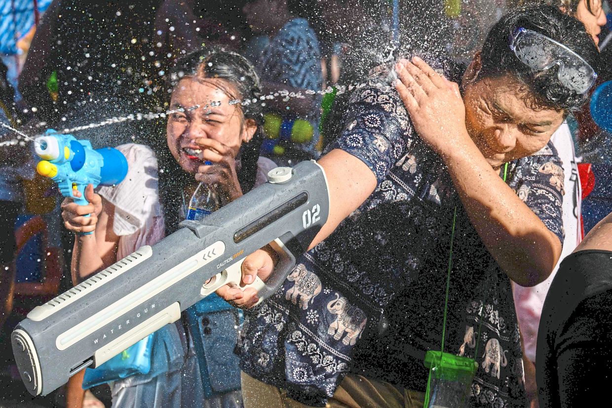 Children participating in splash-filled celebrations, adding youthful energy to the joyful celebration. — AFP