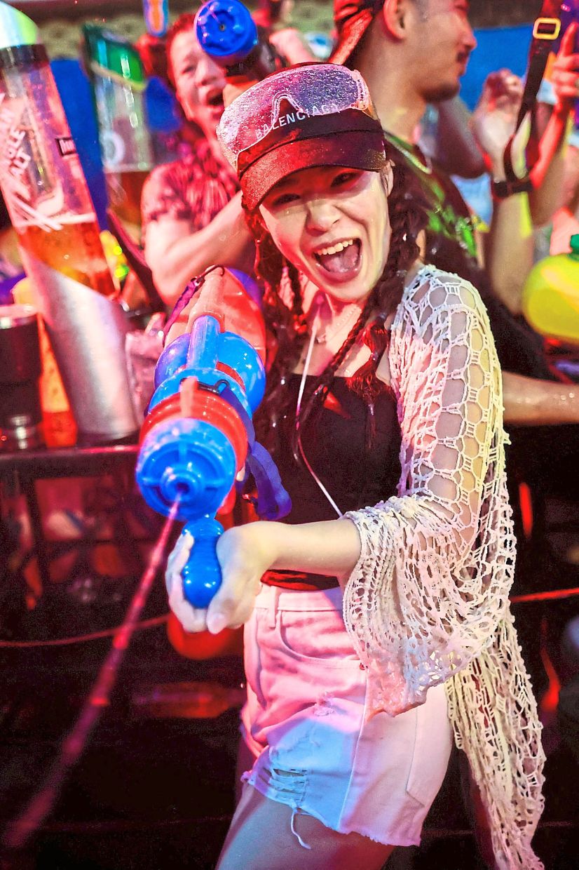 A reveller firing a water gun as crowds celebrate Songkran, the Thai New Year, on Bangkok’s bustling Khaosan Road, a favourite hub for tourists. — Reuters