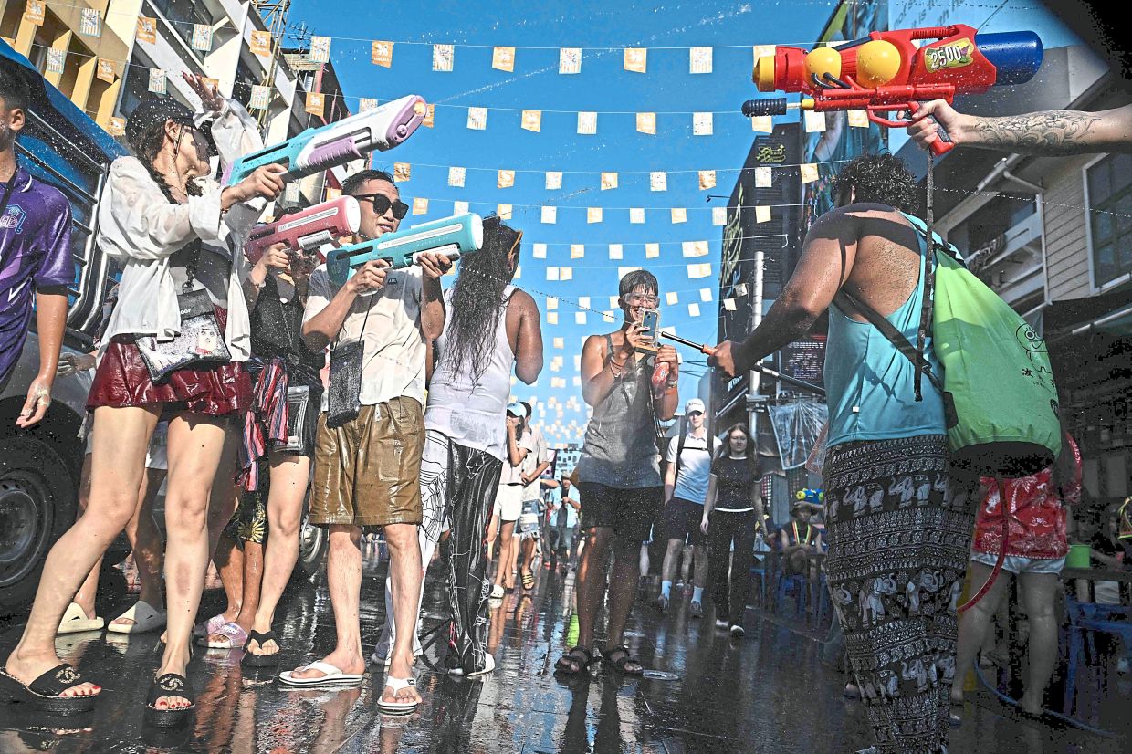 Tourists joining the festive frenzy, splashing water along a road transformed into a playground of celebration. — AFP