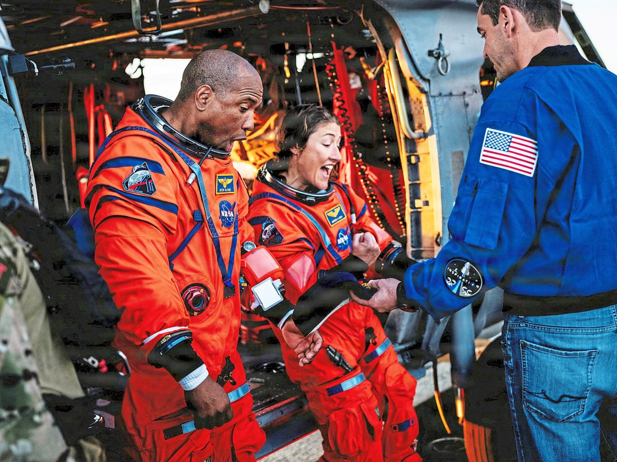 Glover and Koch are presented with customised ship hats aboard the ‘USS John P. Murtha’ after their Artemis II Moon flyby mission. — Reuters