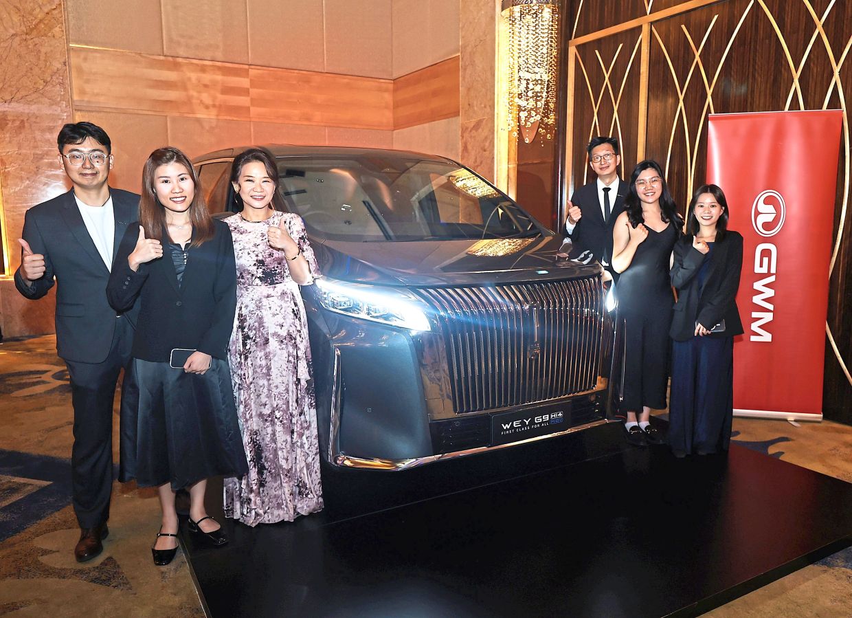 Lim (third left) poses with her team members alongside a showcased GMW car during the event held at One World Hotel in Petaling Jaya, Selangor.
